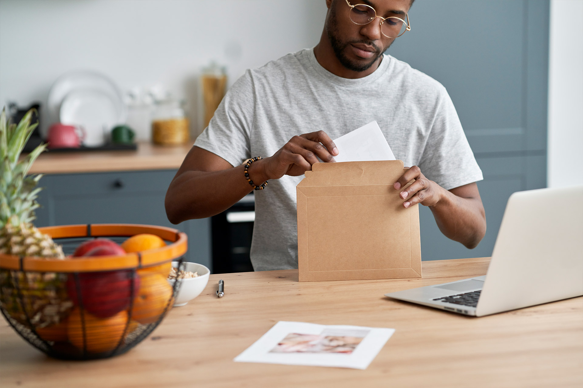 Man preparing a letter for mailing at home office, representing direct mail services in Calgary for small businesses.