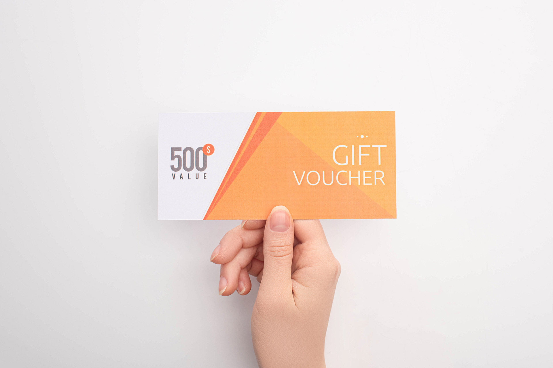 Hand holding a bright orange gift voucher, an example of promotional inserts used in direct mail services in Calgary.