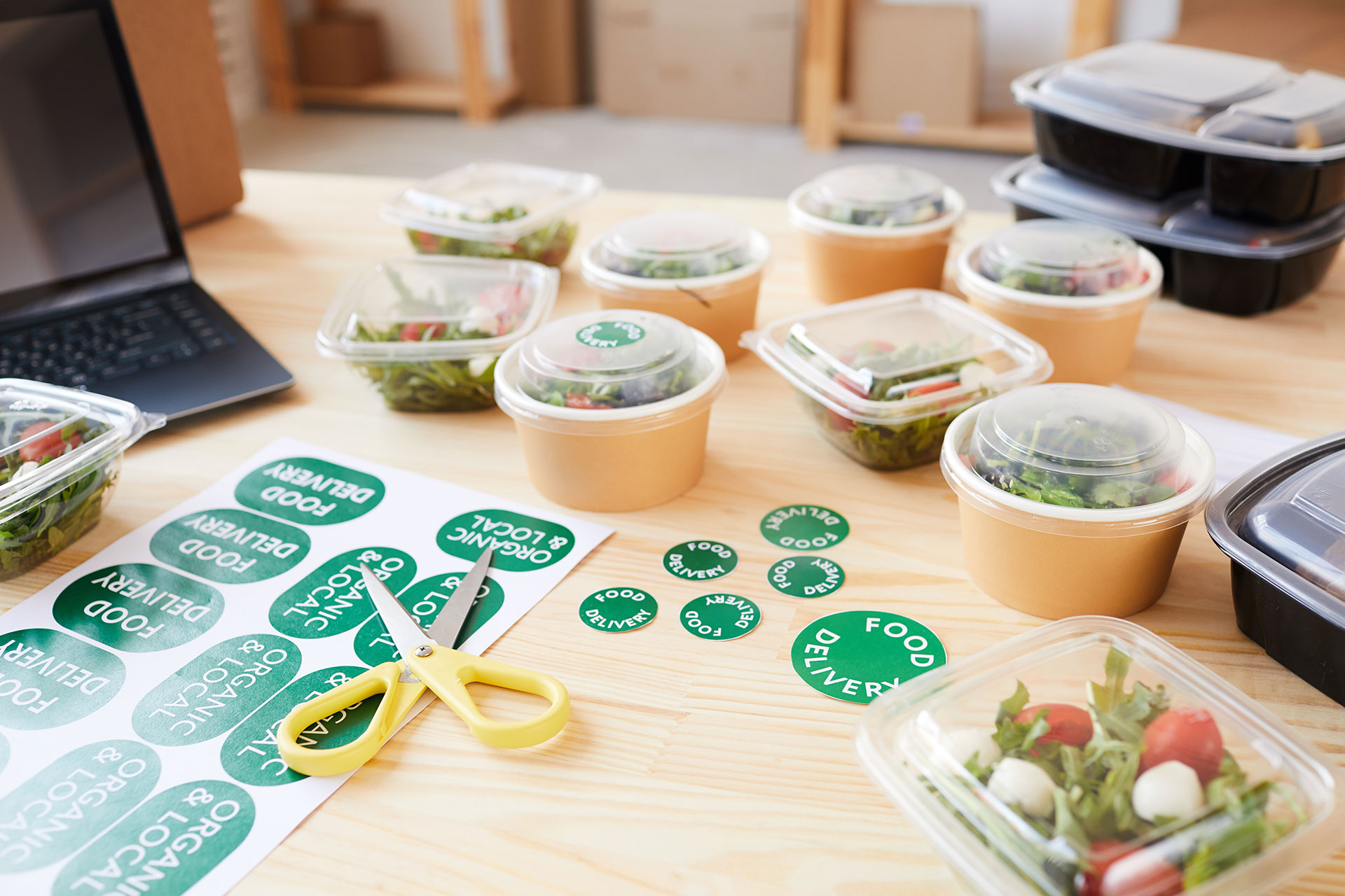Green round labels reading Food Delivery applied to takeout containers, highlighting how businesses use sticker printing in Calgary for packaging.